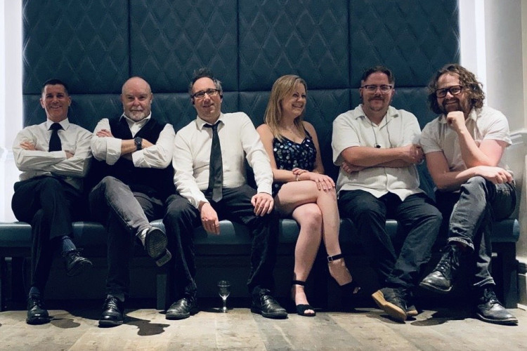 Reunion corporate band six piece seated on a bench, Essex