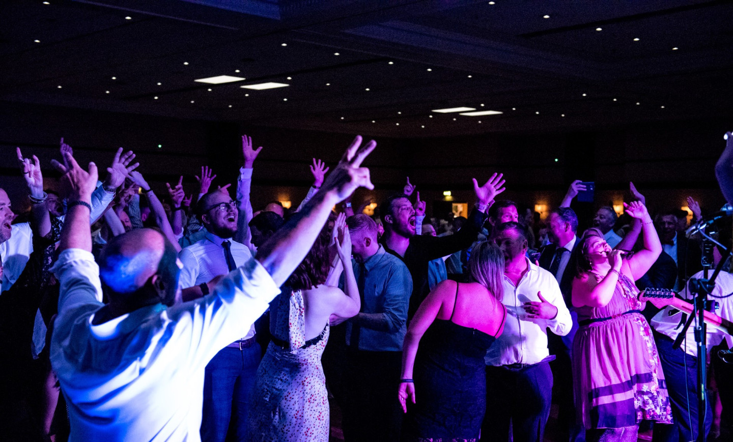 Celebrating a Milestone with Live Entertainment Crowd cheering and celebrating in front of a live band for a milestone birthday or anniversary party